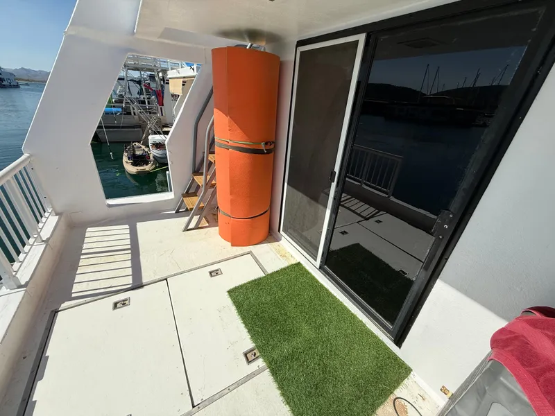 Slide: The Image of Houseboat deck with artificial grass, orange cylinder, and sliding glass door, Three Buoys 5014, 1987. - 26