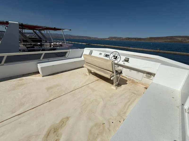 Slide: The Image of 1987 Three Buoys 5014 boat deck with steering wheel, bench seating, and ocean view. - 31