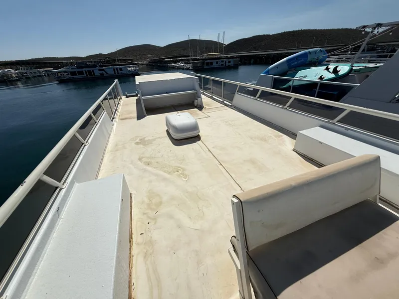 Slide: The Image of Top deck of a 1987 Three Buoys 5014 boat, docked at a marina. - 33