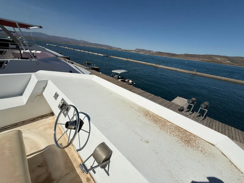 Slide: The Image of 1987 Three Buoys 5014 boat docked by a serene lake with clear blue skies. - 34