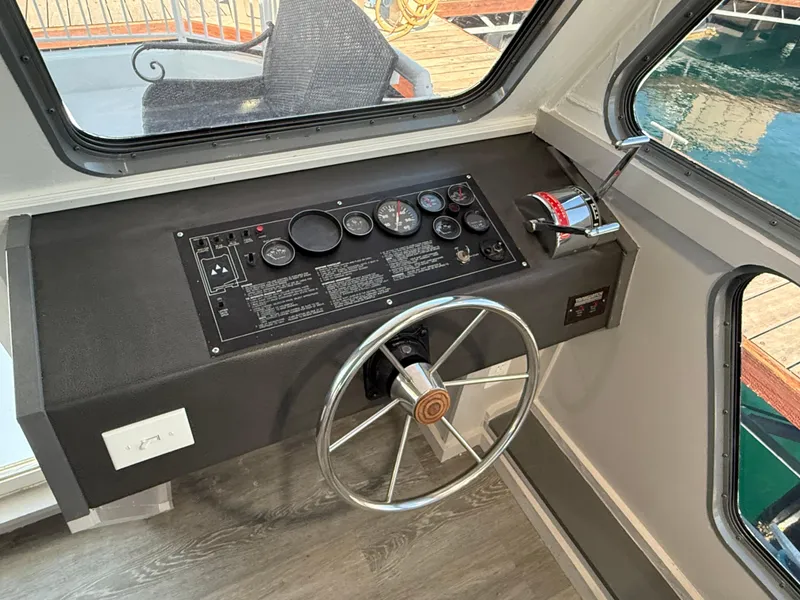 Slide: The Image of Control panel of a 1987 Three Buoys 5014 boat with steering wheel and gauges. - 39