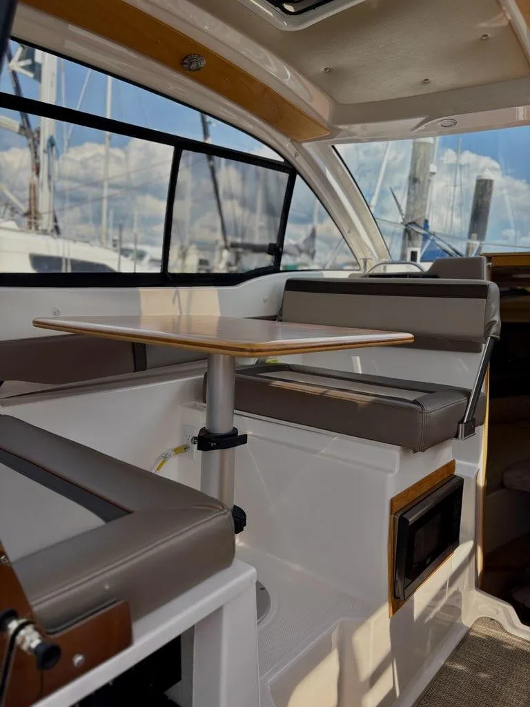 Slide: The Image of 2022 Cutwater C-248 Coupe interior with seating and table, featuring large windows. - 18