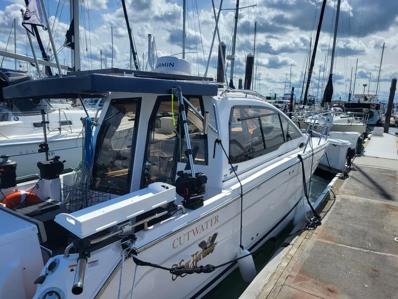 Slide: The Image of 2022 Cutwater C-248 Coupe docked at marina under cloudy sky. - 2