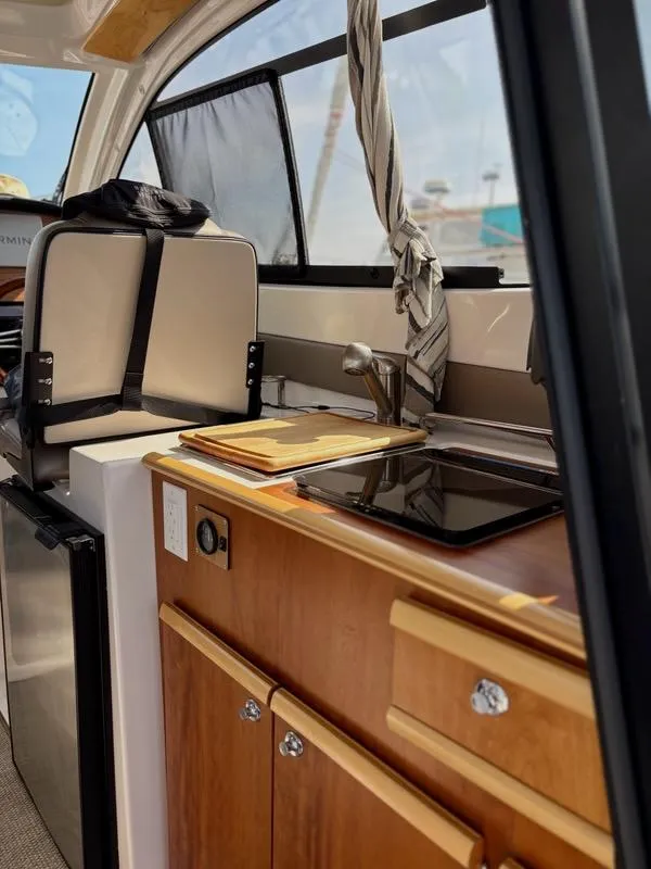 Slide: The Image of Interior of 2022 Cutwater C-248 Coupe featuring compact kitchen with sink and stove. - 20