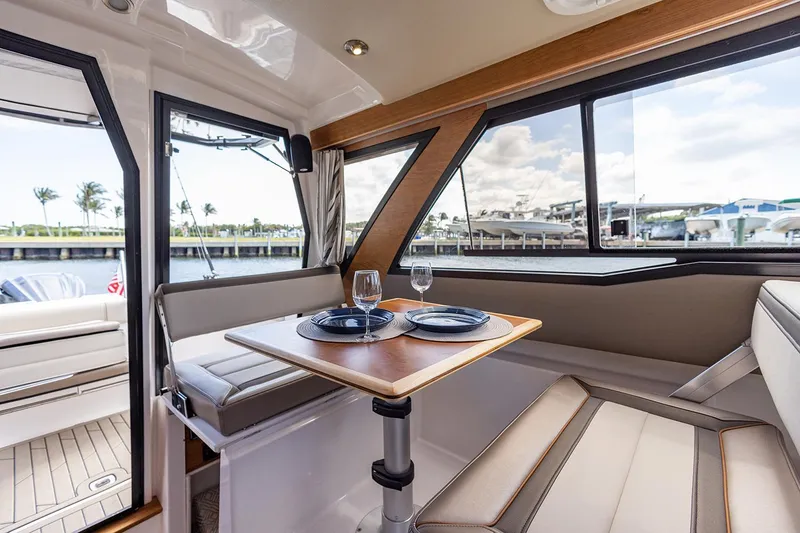 Slide: The Image of Manufacturer Provided Image: Interior of 2022 Cutwater C-248 Coupe with dining area and waterfront view. - 9