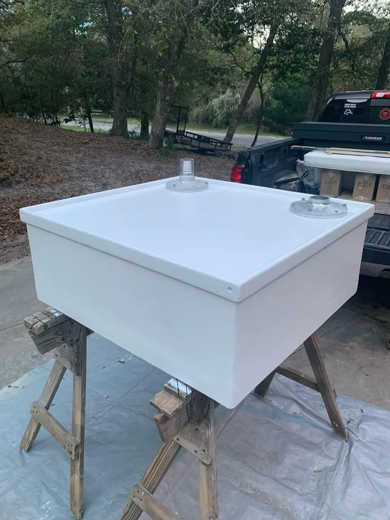 Slide: The Image of White rectangular tank on sawhorses, outdoors, near a truck. - 17