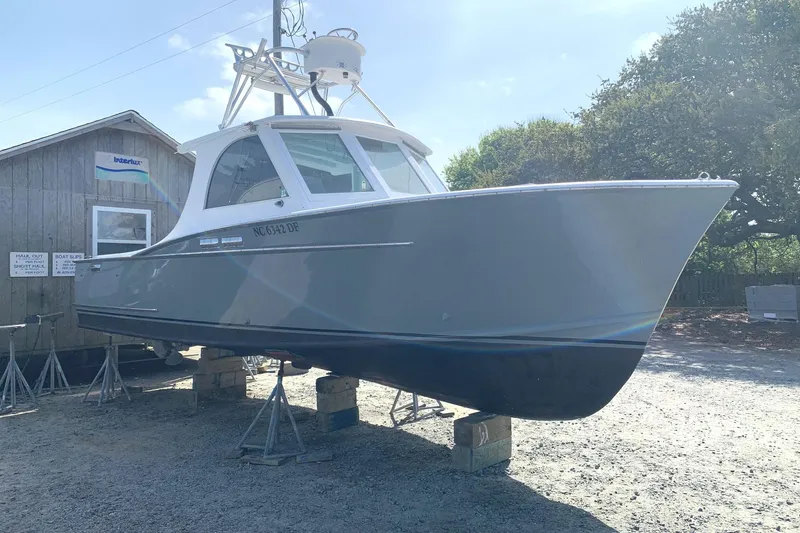 Slide: The Image of 1975 Custom Carolina Warren O'Neal boat on stands, gray hull, outdoor setting. - 2