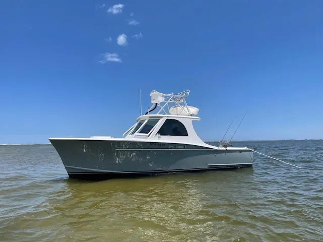 Slide: The Image of 1975 Custom Carolina Warren O'Neal boat on calm water under clear blue sky. - 21