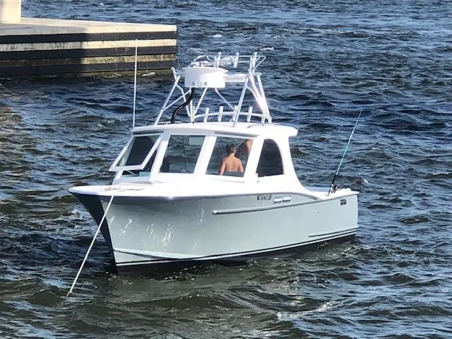 Slide: The Image of Custom Carolina Warren O'Neal 1975 boat on water near dock, with fishing rods visible. - 3