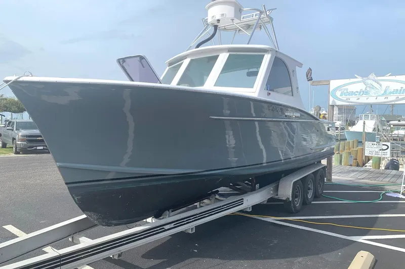 Slide: The Image of 1975 Custom Carolina Warren O'Neal boat on trailer at marina, clear sky background. - 4