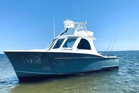 Slide: The Image of 1975 Custom Carolina Warren O'Neal boat on calm water under clear blue sky. - 5