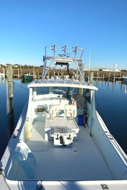 Slide: The Image of 1975 Custom Carolina Warren O'Neal boat docked in a marina under clear blue skies. - 6