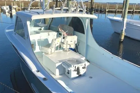 Slide: The Image of 1975 Custom Carolina Warren O'Neal boat docked, featuring spacious deck and seating. - 8