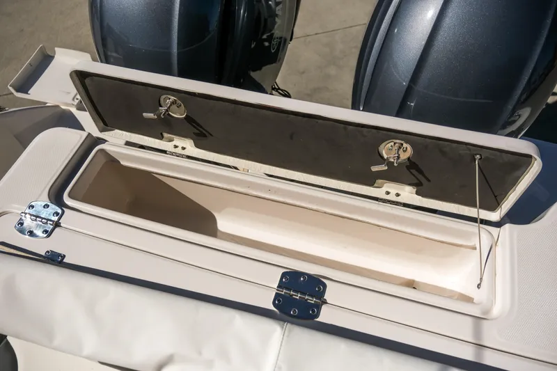 Slide: The Image of Open storage compartment on 2022 Robalo R247 DC boat, showcasing interior space and latches. - 14