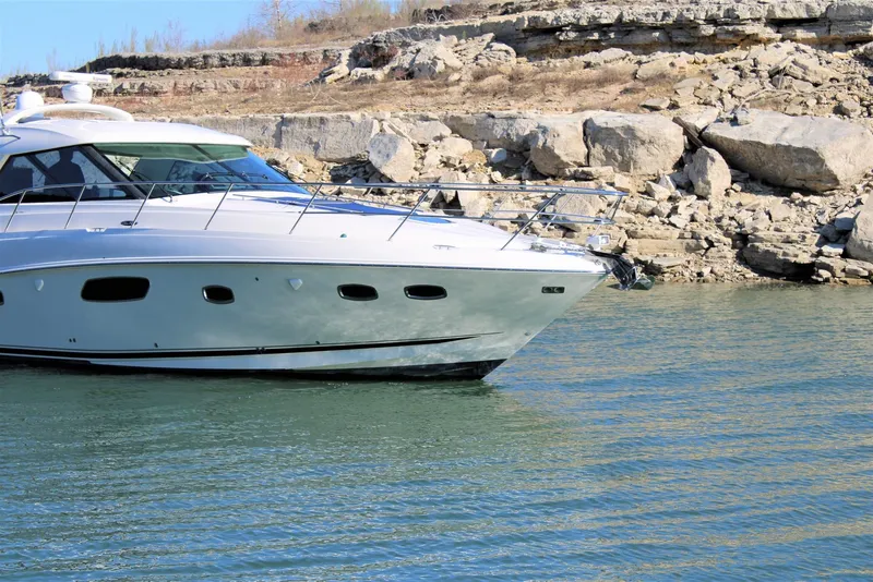 Slide: The Image of 2012 Sea Ray 450 Sundancer yacht cruising near rocky shoreline. - 10