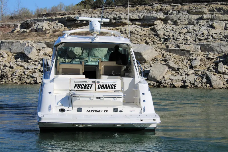 Slide: The Image of 2012 Sea Ray 450 Sundancer yacht named "Pocket Change" on a lake near rocky shore. - 15
