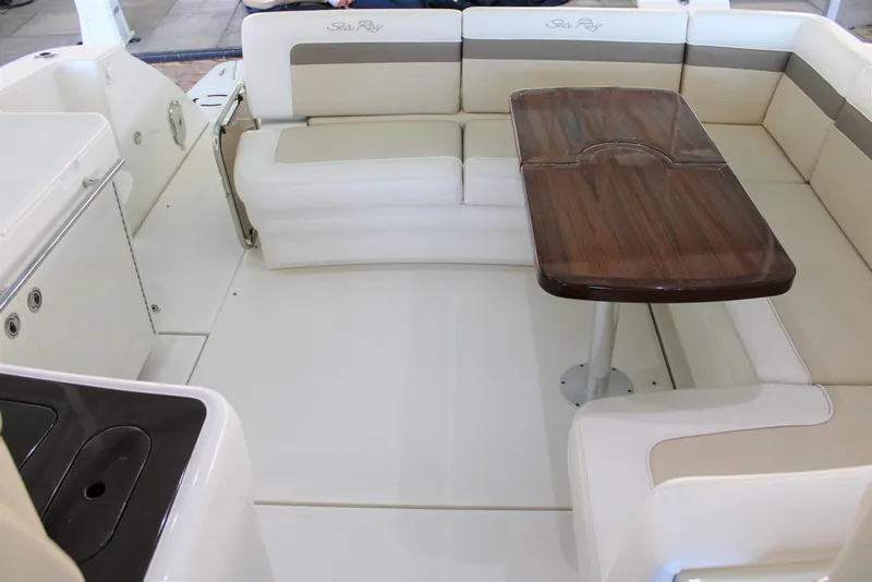 Slide: The Image of 2012 Sea Ray 450 Sundancer interior with beige seating and wooden table. - 23