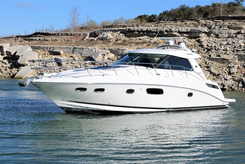 Slide: The Image of 2012 Sea Ray 450 Sundancer yacht cruising near rocky shoreline. - 3