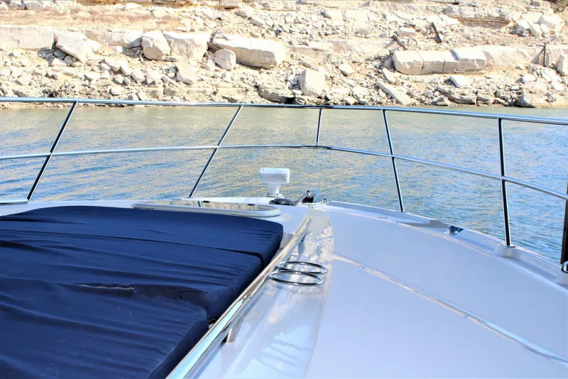Slide: The Image of Bow of 2012 Sea Ray 450 Sundancer yacht with water and rocky shoreline. - 33