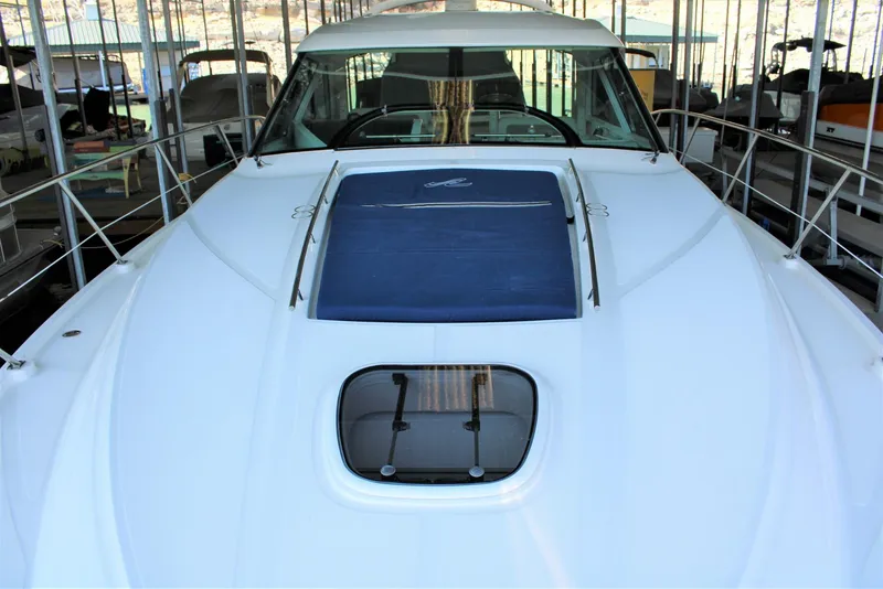 Slide: The Image of 2012 Sea Ray 450 Sundancer yacht docked, showcasing sleek design and spacious deck. - 36