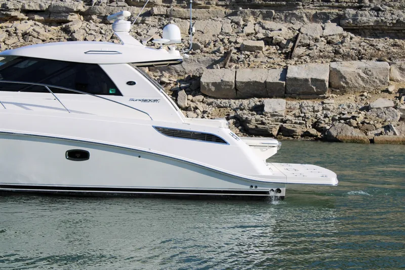 Slide: The Image of 2012 Sea Ray 450 Sundancer yacht near rocky shoreline. - 5