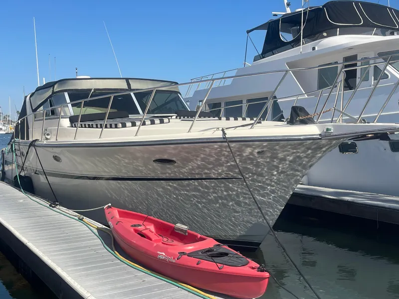 The Image of 1988 Californian express cruiser docked with a red kayak in the foreground. - 0