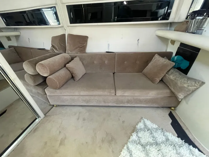 Slide: The Image of 1988 Californian express cruiser interior with beige sofa and plush cushions. - 16
