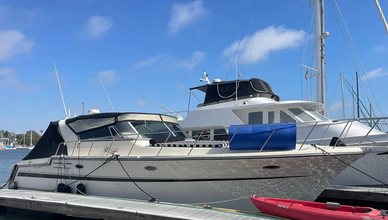 Slide: The Image of 1988 Californian express cruiser docked at marina under clear blue sky. - 36