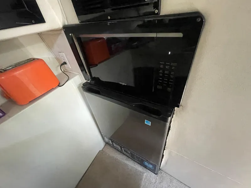 Slide: The Image of Kitchen area in a 1988 Californian express cruiser with microwave and orange toaster. - 9