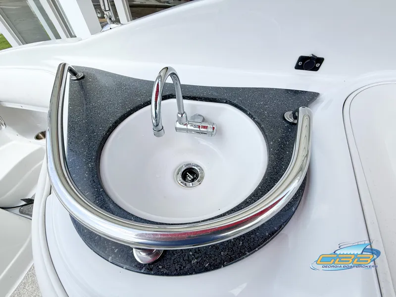 Slide: The Image of 2006 Crownline 260 EX boat sink with chrome faucet and black countertop. - 20
