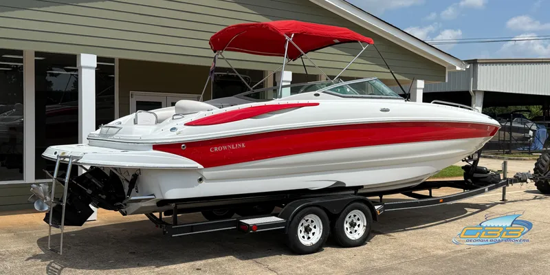Slide: The Image of 2006 Crownline 260 EX boat with red accents and canopy on a trailer. - 4