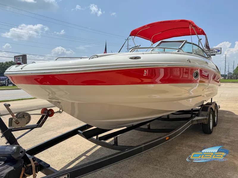Slide: The Image of 2006 Crownline 260 EX boat with red accents on a trailer, sunny day background. - 7