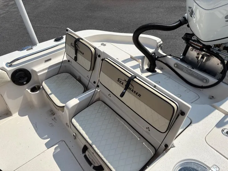 Slide: The Image of 2021 Sea Chaser 23 LX boat interior with cushioned seating and motor detail. - 19