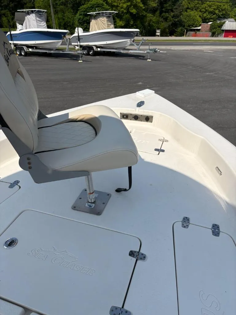 Slide: The Image of 2021 Sea Chaser 23 LX boat with cushioned seat and storage compartments. - 20