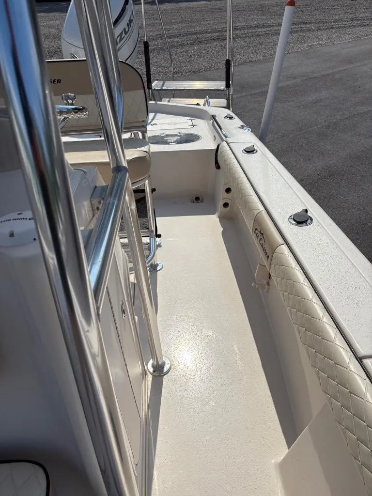 Slide: The Image of 2021 Sea Chaser 23 LX boat interior with seating and railing, featuring Suzuki engine. - 26