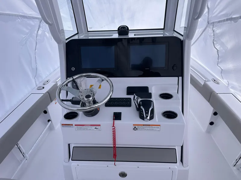 Slide: The Image of 2025 Sportsman Masters 247OE Bay Boat helm with dual screens and steering wheel. - 15