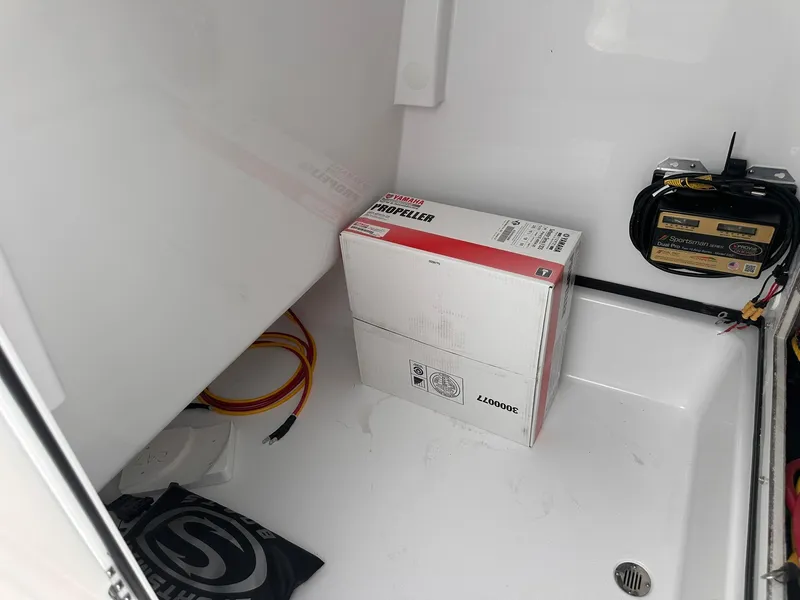 Slide: The Image of Storage compartment of 2025 Sportsman Masters 247OE Bay Boat with propeller box and cables. - 25