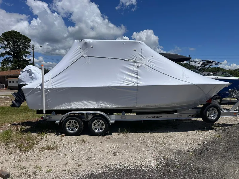Slide: The Image of 2025 Sportsman Masters 247OE Bay Boat covered on trailer, outdoors under blue sky. - 3