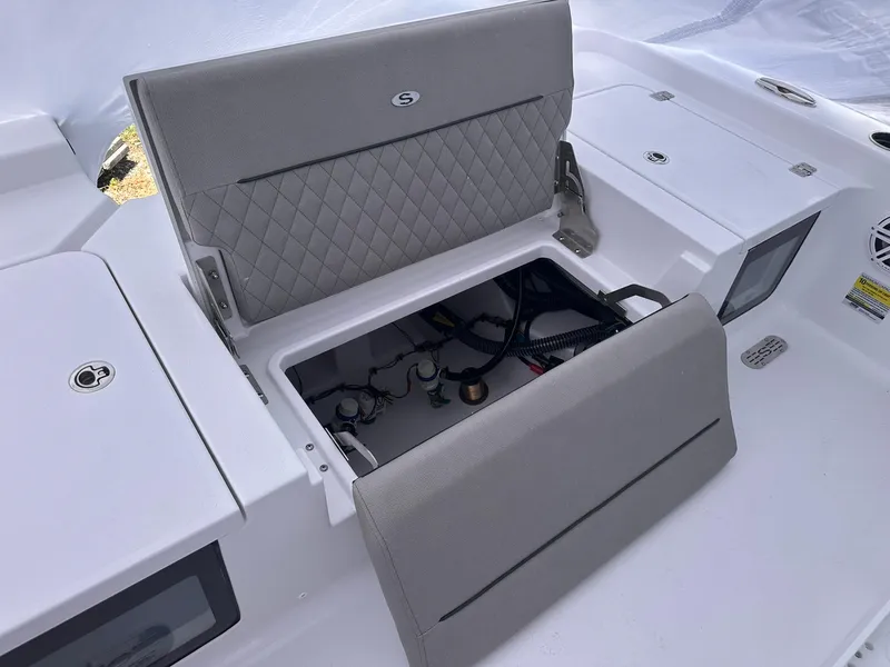 Slide: The Image of 2025 Sportsman Masters 247OE Bay Boat storage compartment with open hatch and visible wiring. - 45