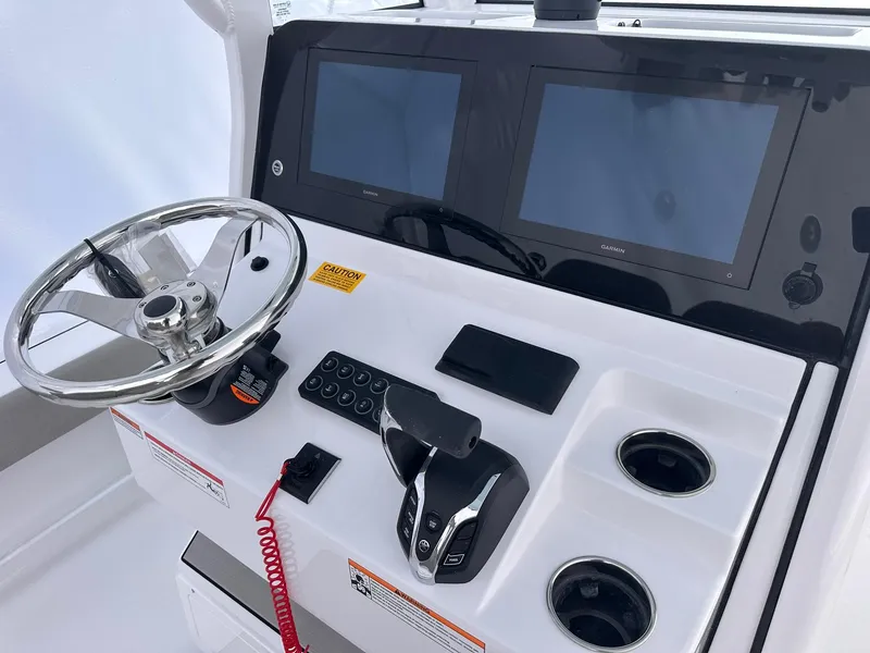Slide: The Image of Control panel of 2025 Sportsman Masters 247OE Bay Boat with dual screens and steering wheel. - 47