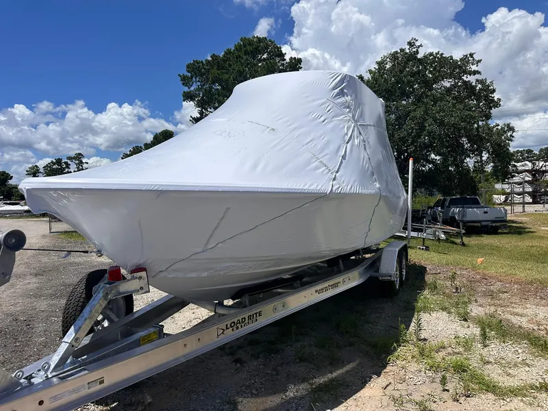 Slide: The Image of 2025 Sportsman Masters 247OE Bay Boat covered on trailer, outdoors under blue sky. - 5