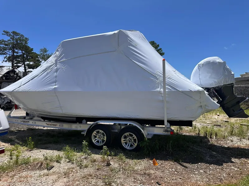 Slide: The Image of 2025 Sportsman Masters 247OE Bay Boat covered on trailer, outdoors under blue sky. - 6