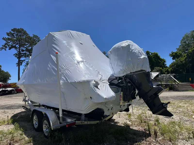 Slide: The Image of 2025 Sportsman Masters 247OE Bay Boat covered, on trailer, outdoors under clear blue sky. - 7
