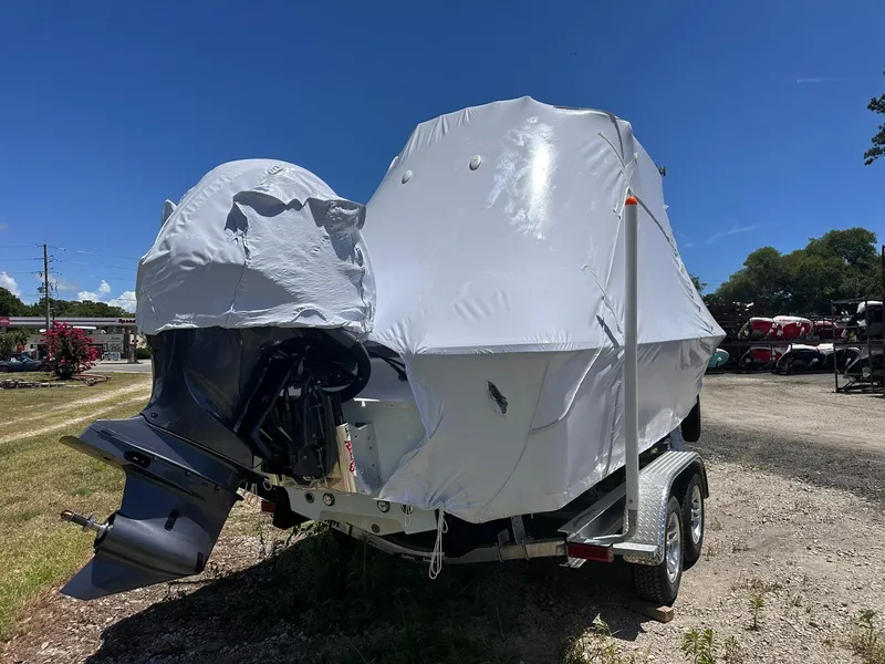 Slide: The Image of 2025 Sportsman Masters 247OE Bay Boat covered, on trailer, outdoors under clear sky. - 9