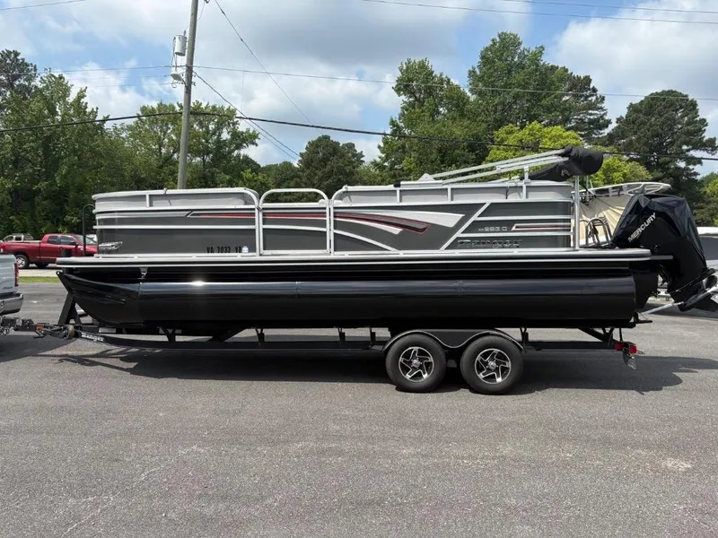 Slide: The Image of 2022 Ranger Reata 223C pontoon boat on trailer, parked outdoors. - 3