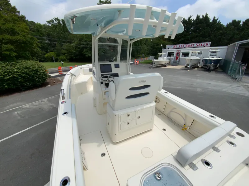 Slide: The Image of 2023 Cobia 240 Center Console boat at dealership, showcasing helm and seating area. - 11