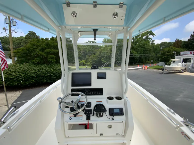 Slide: The Image of 2023 Cobia 240 Center Console boat interior with steering wheel and navigation equipment. - 12
