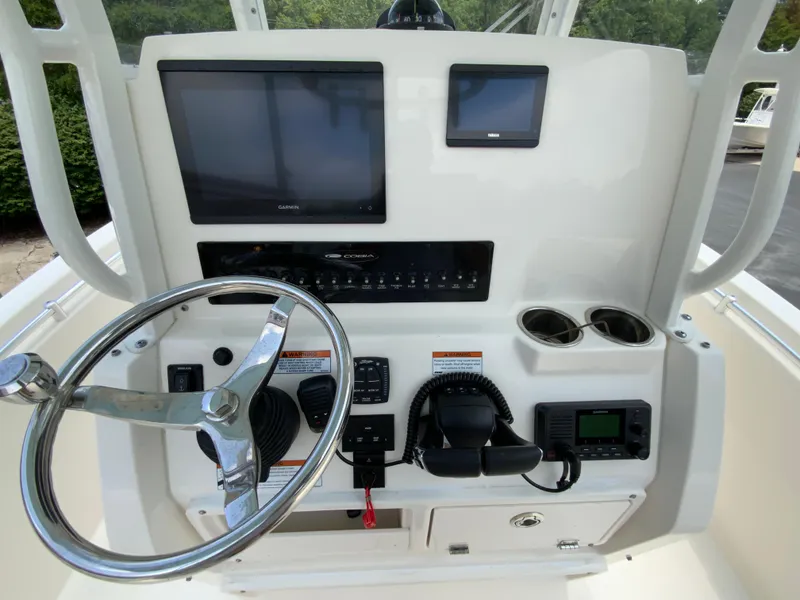 Slide: The Image of 2023 Cobia 240 Center Console dashboard with steering wheel, navigation screens, and controls. - 13