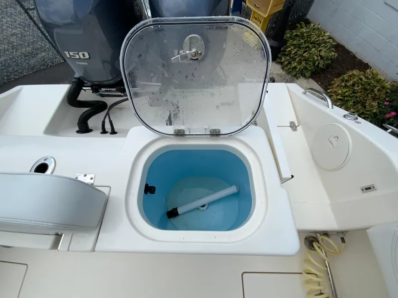 Slide: The Image of 2023 Cobia 240 Center Console boat with open livewell and Yamaha 150 engine. - 18