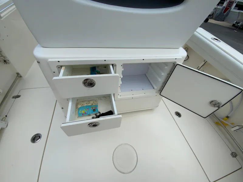 Slide: The Image of 2023 Cobia 240 Center Console boat storage compartments with open drawers and cabinet. - 20